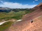 A hiker headed down a rocky hill in the Rockies.